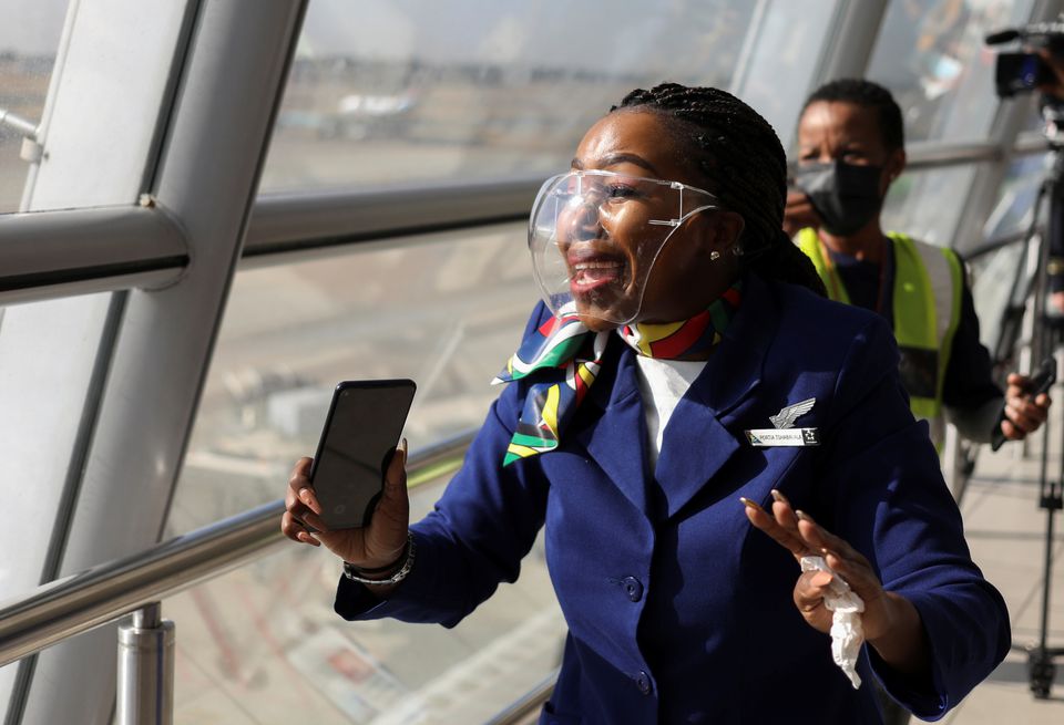 A cabin crew member reacts as South Africa's national airline, South African Airways (SAA), prepares to take off after a year-long hiatus triggered by it running out of funds, at O.R. Tambo International Airport in Johannesburg, South Africa, September 23, 2021. REUTERS/Siphiwe Sibeko