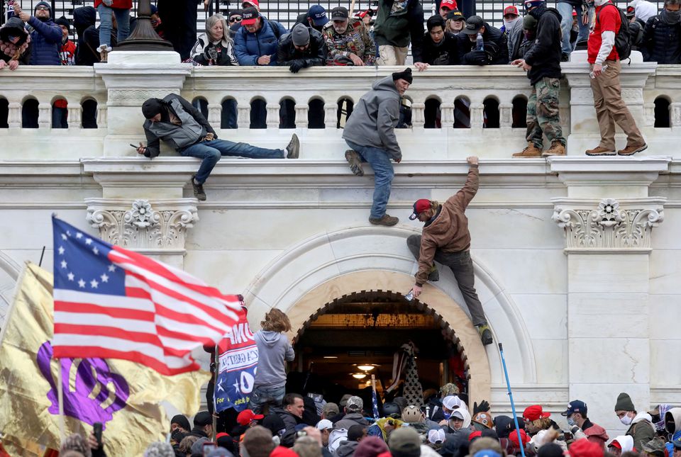 A mob of supporters of U.S. President Donald Trump fight with members of law enforcement at a door they broke open as they storm the U.S. Capitol Building in Washington, U.S., January 6, 2021. REUTERS/Leah Millis