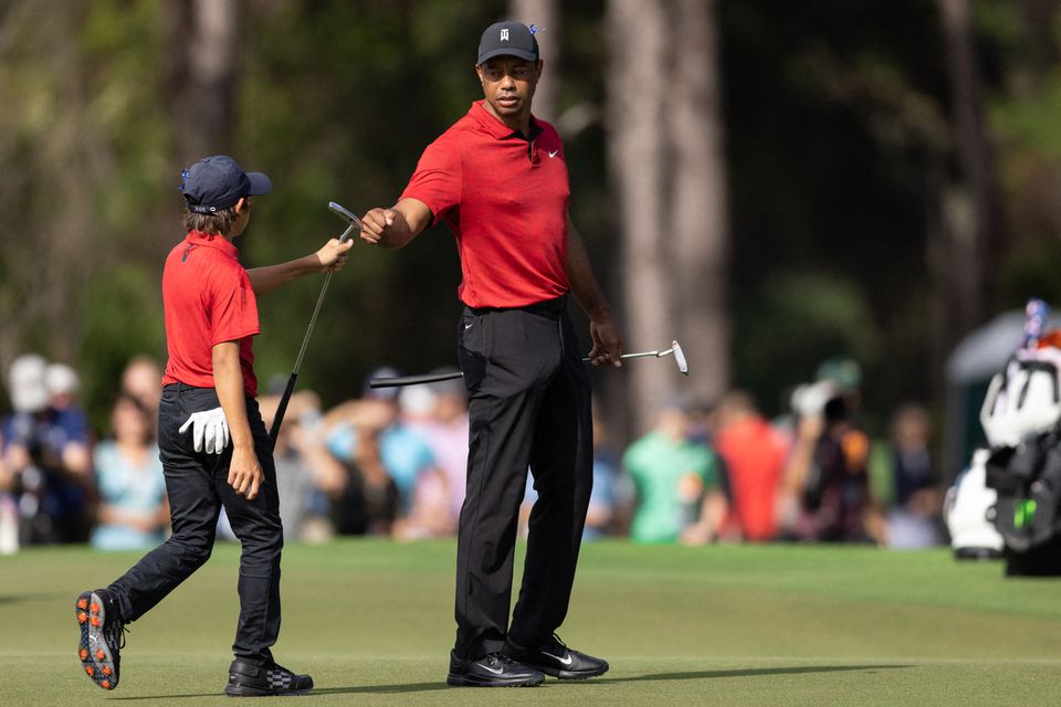 Dec 19, 2021; Orlando, Florida, USA; Charlie Woods and Tiger Woods celebrate an eagle putt on the third green during the final round of the PNC Championship golf tournament at Grande Lakes Orlando Course. Mandatory Credit: Jeremy Reper-USA TODAY Sports