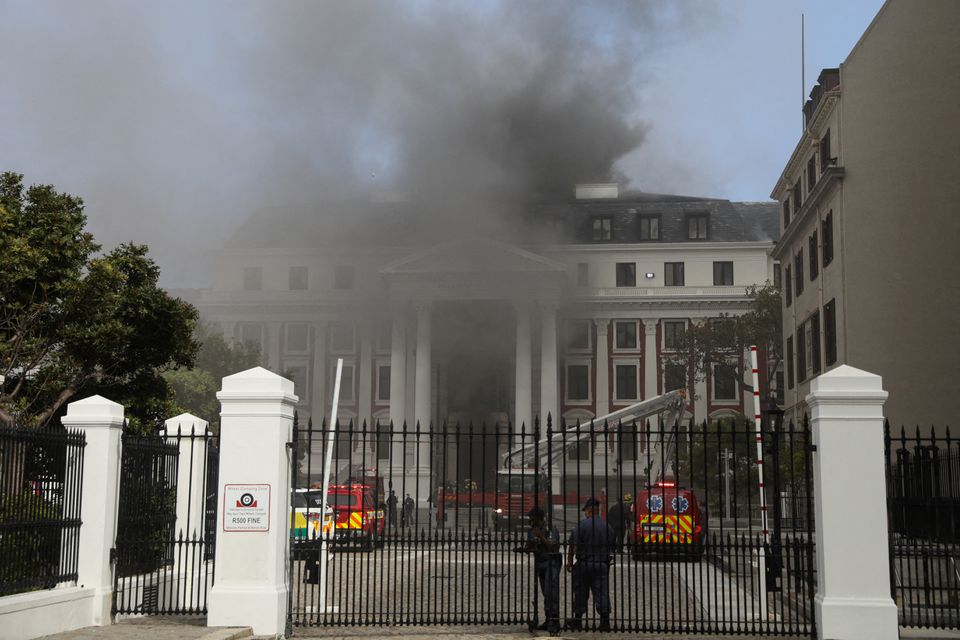 Firefighters work among the smoke after a fire broke out in the Parliament in Cape Town, South Africa. REUTERS/Sumaya Hisham