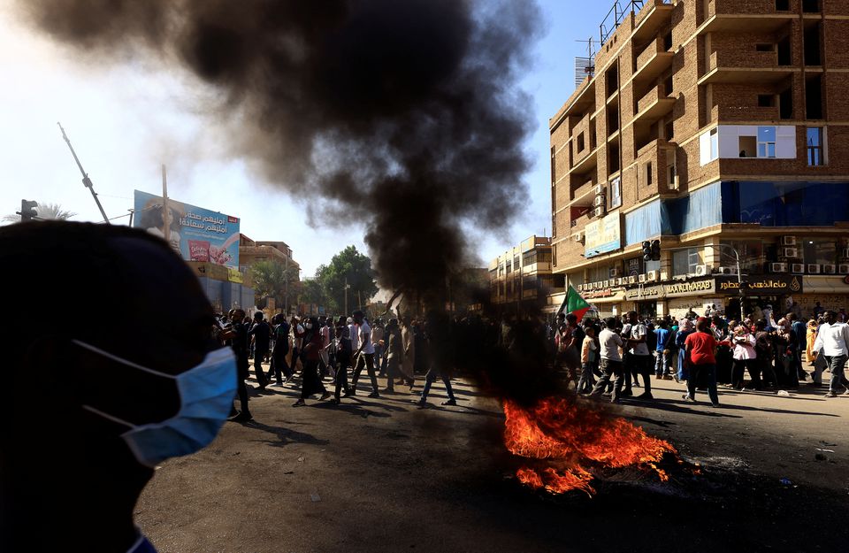 Tires burn on the ground as protesters march during a rally against military rule, following last month's coup in Khartoum North, Sudan, January 6, 2022. REUTERS/Mohamed Nureldin Abdallah